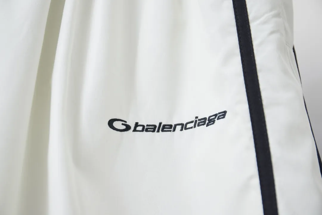 Balenciaga 𝘽𝘼𝙇𝙀𝙉𝘾𝙄𝘼𝙂𝘼 BLCG 25SS double-split waterproof sports pants. Light luxury. A must-have item for daily commuting for men and women. Correct version. Welcome to compare. Detailed features · Customized matt Taslan jacket fabric · The entire fabric is pre-treated with a waterproof coating · The interior is made of three-level polyester bird's eye mesh · OS ultra-loose silhouette design · Side pockets · Elastic waistband design · Contrast color Black webbing splicing · Front and rear contrast color splicing and cutting design · Imported Tajima machine embroidery ring logo · Original main mark washed tag brand packaging Color: White/Royal Blue Size: 46/48/50/52